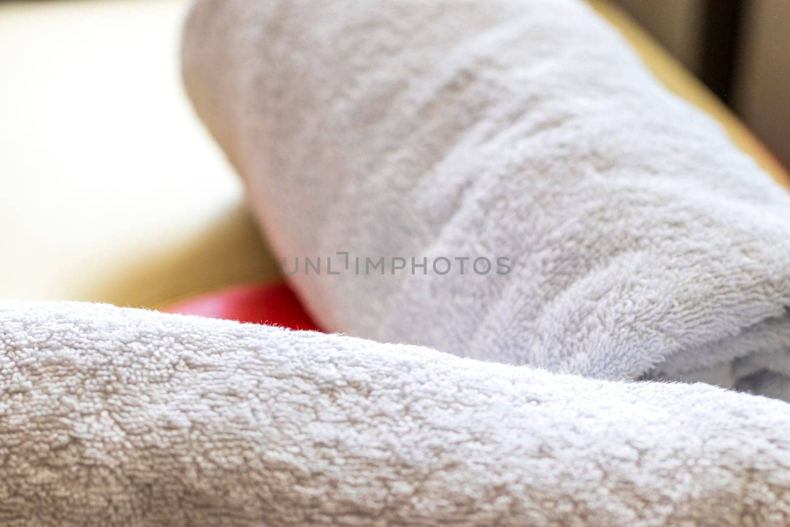 Close up shot of the white towels rolled in the massage couch.