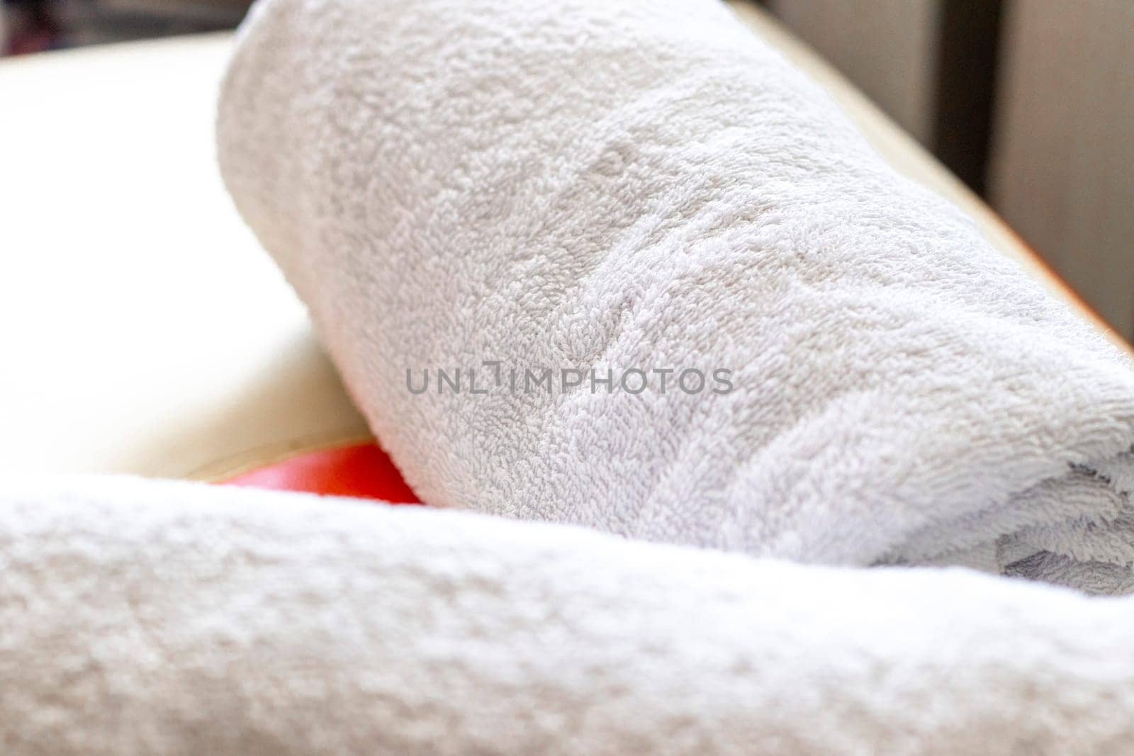 Close up shot of the white towels rolled in the massage couch. Therapy by pazemin