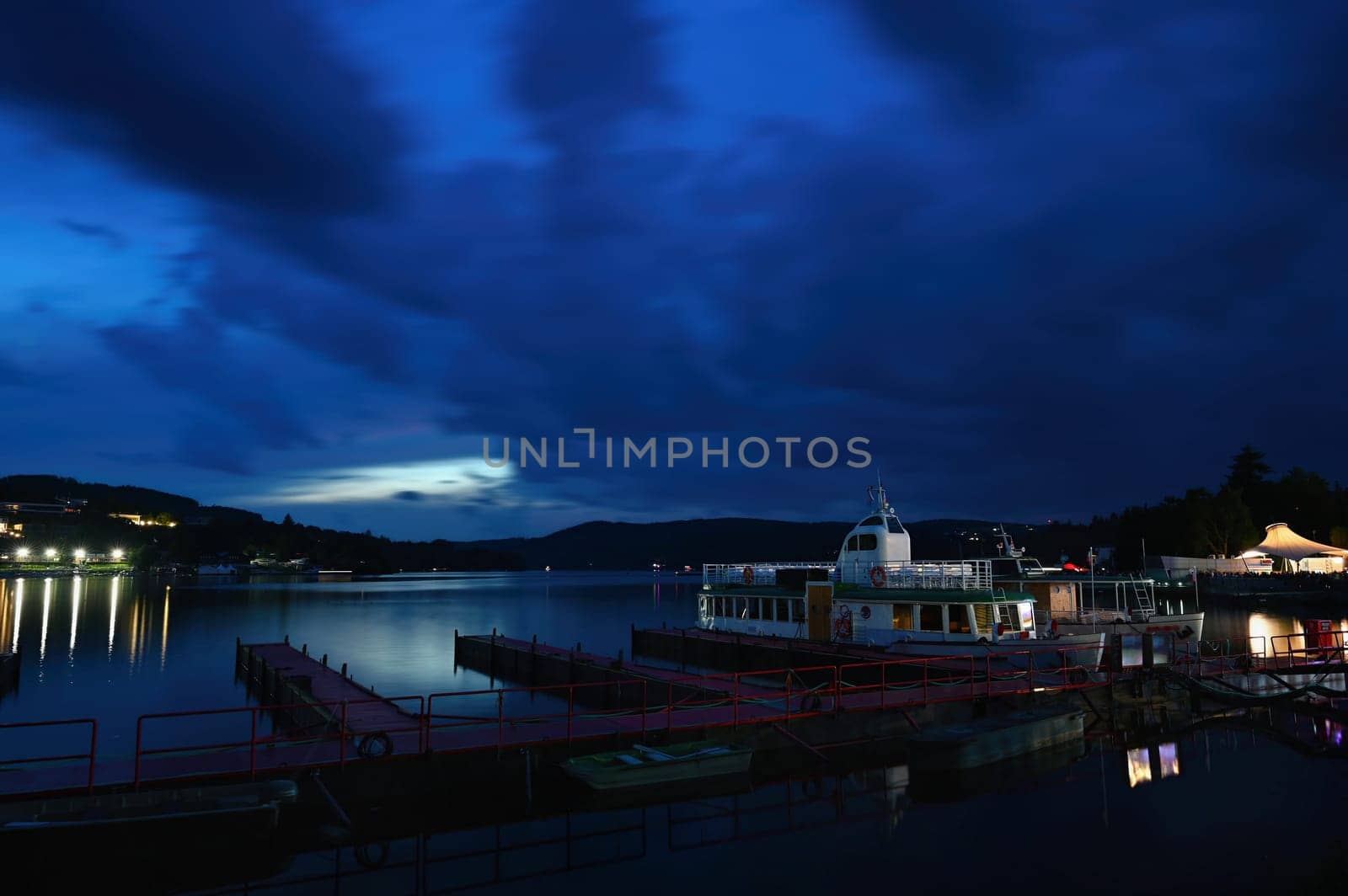Brno Reservoir - Czech Republic, city of Brno. Evening in the blue hour. Ship in port. by Montypeter