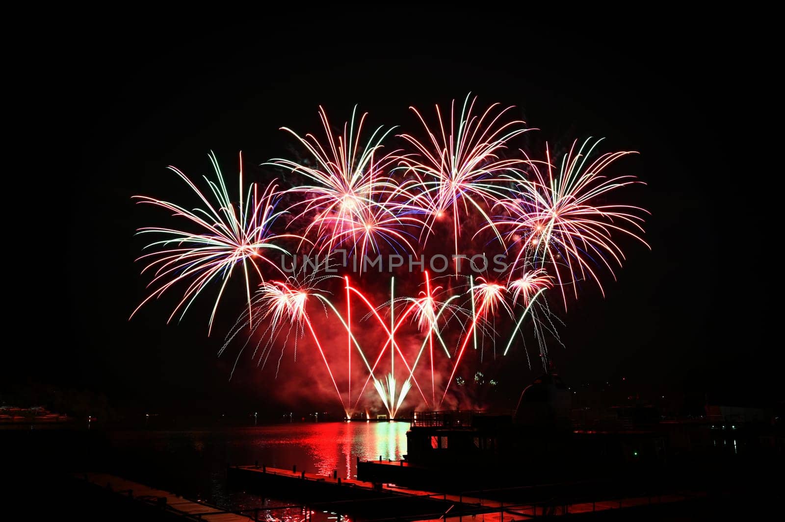 Firework. Beautiful colorful fireworks on the water surface with a clean black background. Fun festival and contest of Firefighters. Brno Dam - Czech Republic. by Montypeter