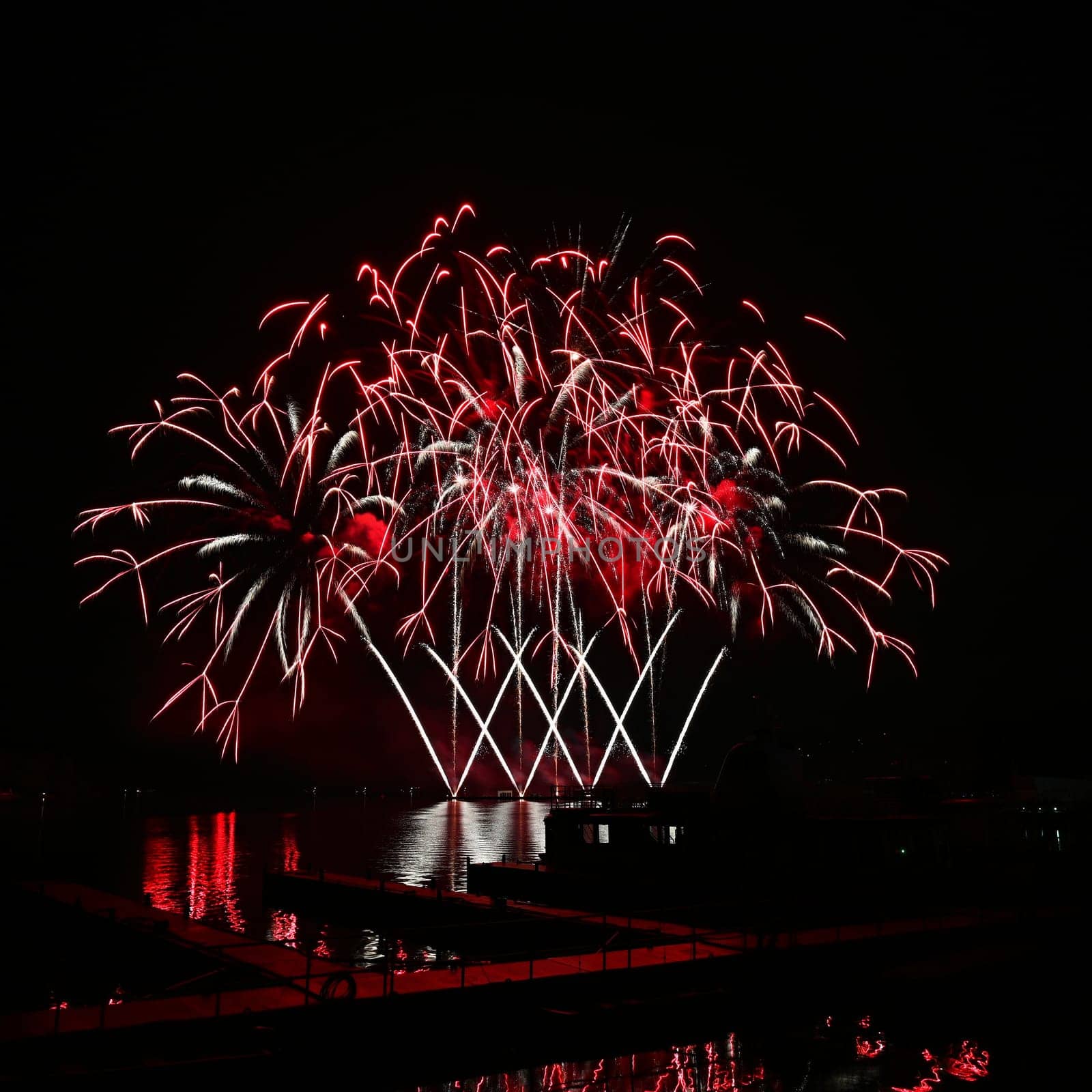 Firework. Beautiful colorful fireworks on the water surface with a clean black background. Fun festival and contest of Firefighters. Brno Dam - Czech Republic.