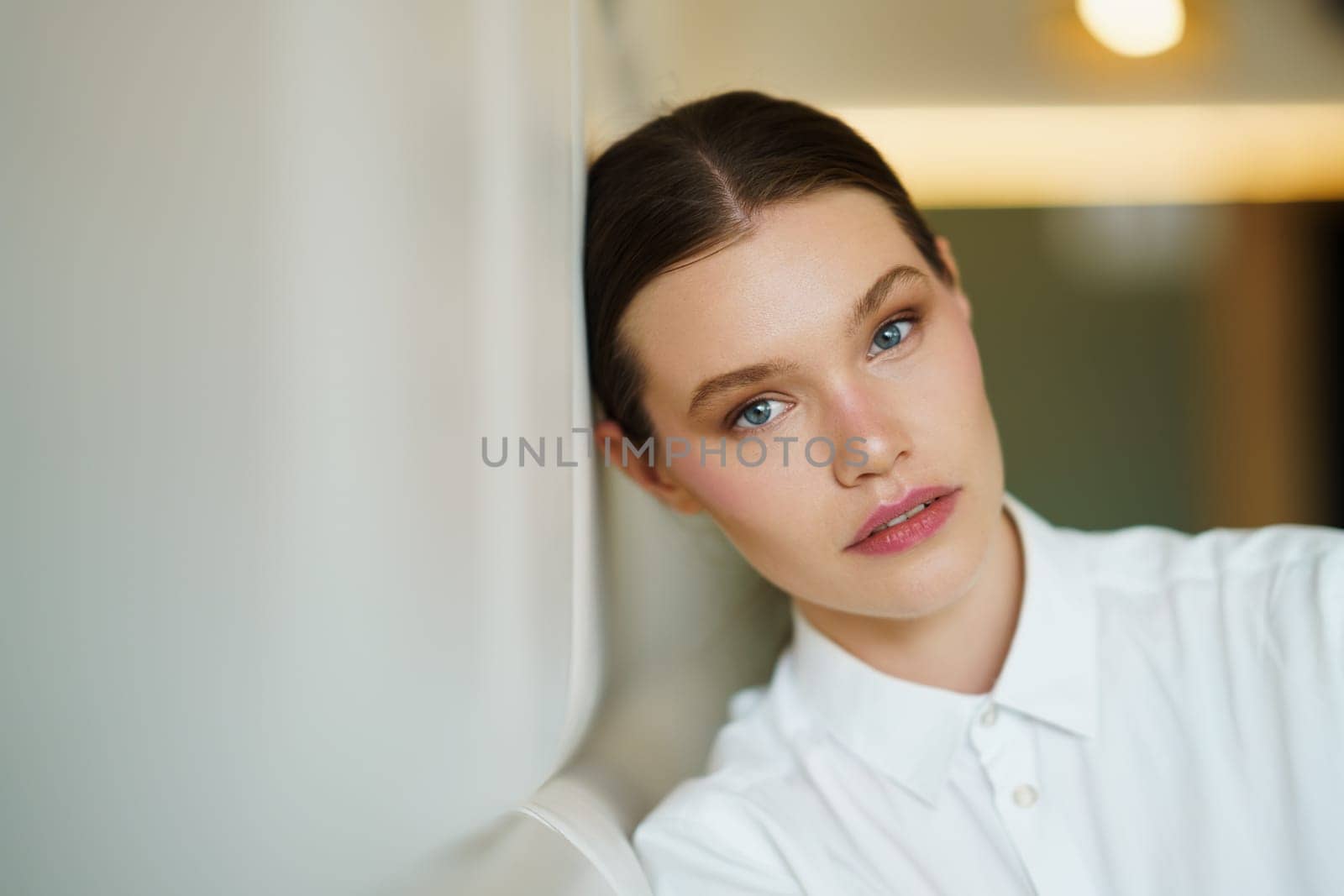 Beauty successful female young entrepreneur leaning the head on a comfortable wall of a cafeteria