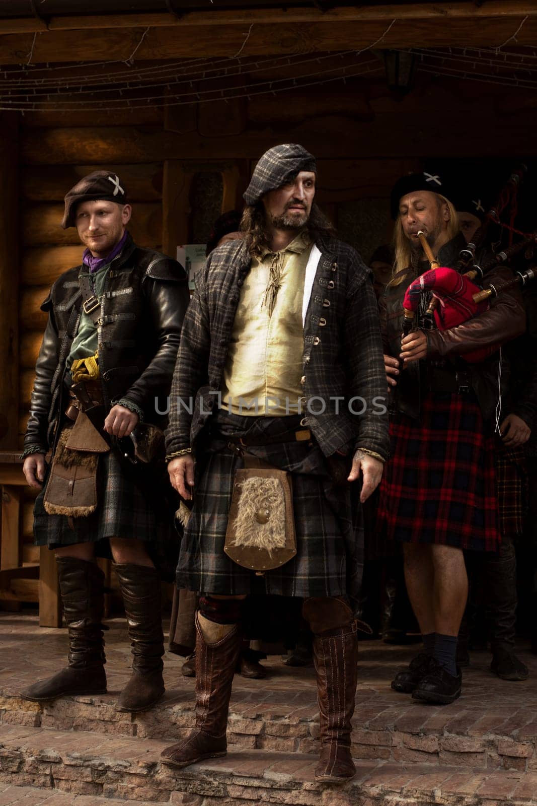 A lord of one of the Scottish clans with his people. Piper. Scotland