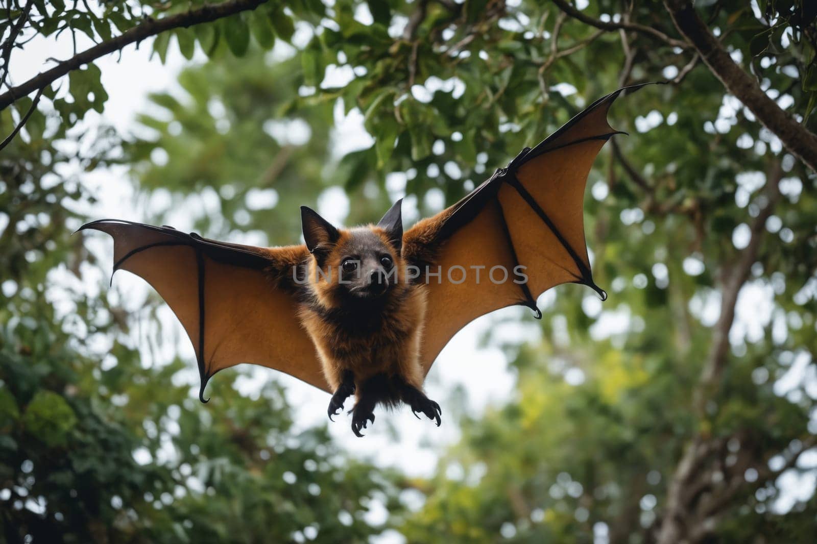 Close-up of a bat with its wings extended, perched on a tree branch amidst green foliage.