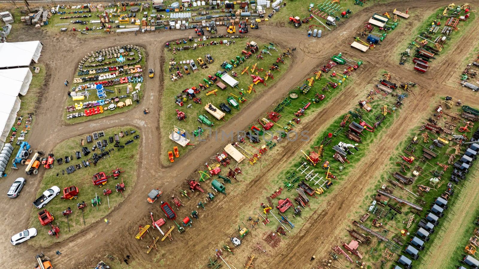 Gordonville, Pennsylvania, USA, March 3, 2024 - Aerial View Of A Large Agricultural Fair With Rows Of Colorful Farming Equipment, Vehicles, And Various Items Displayed On Grassy Fields, Highlighting An Active Marketplace In A Rural Setting.