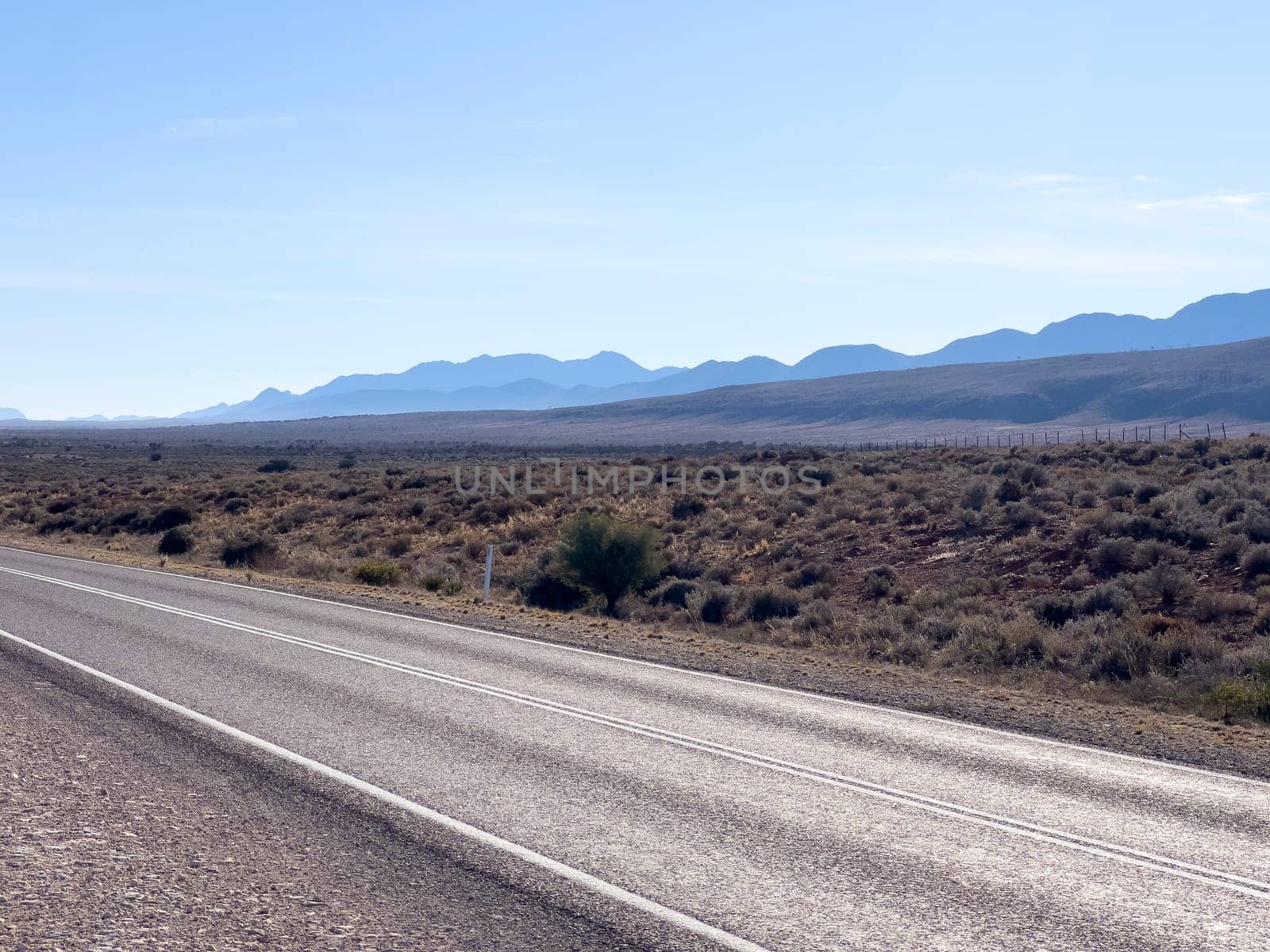A long, deserted road stretches towards distant mountains in Ikara Flinders Ranges