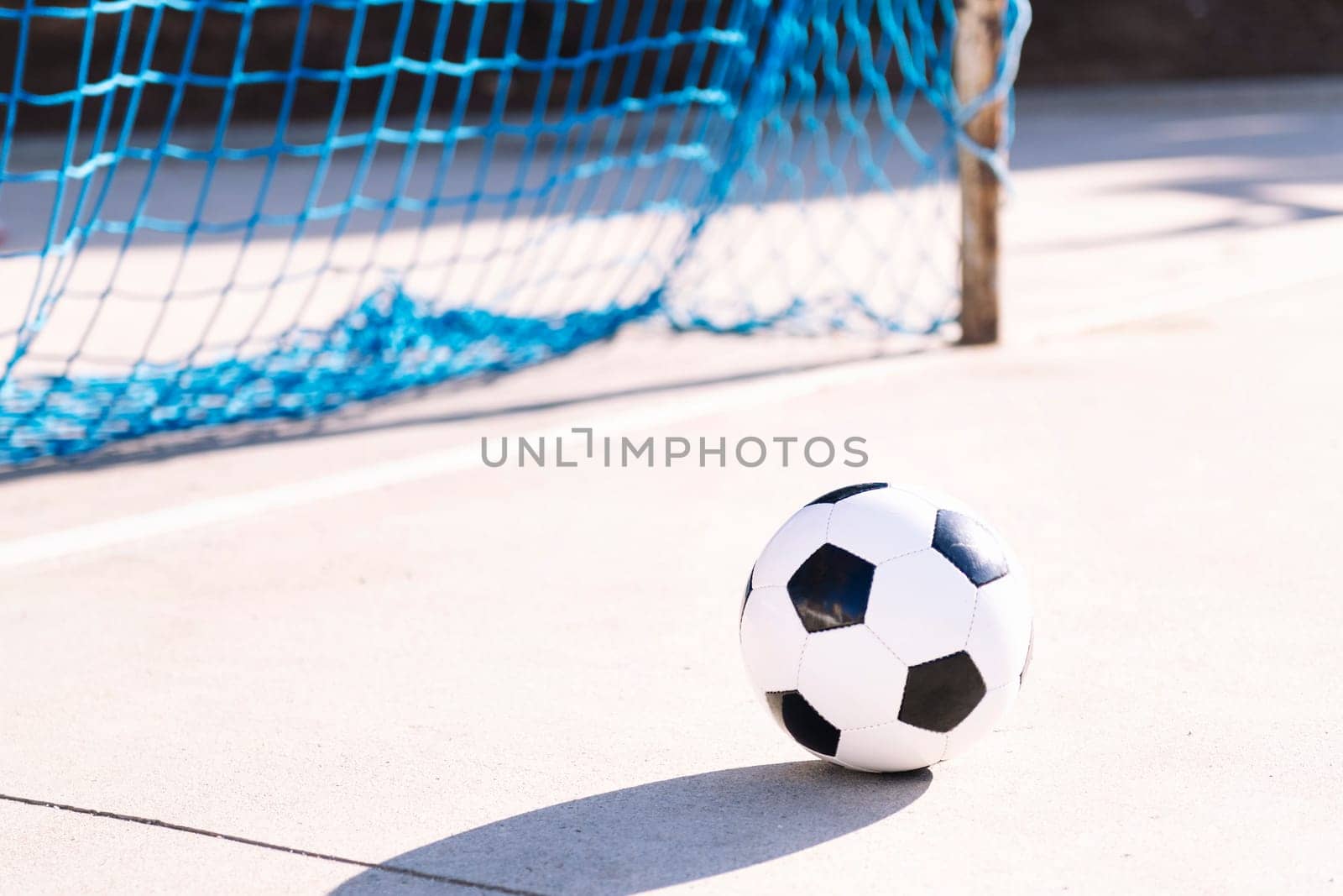 soccer ball next to the goal of an urban football court, concept of sport, copy space for text