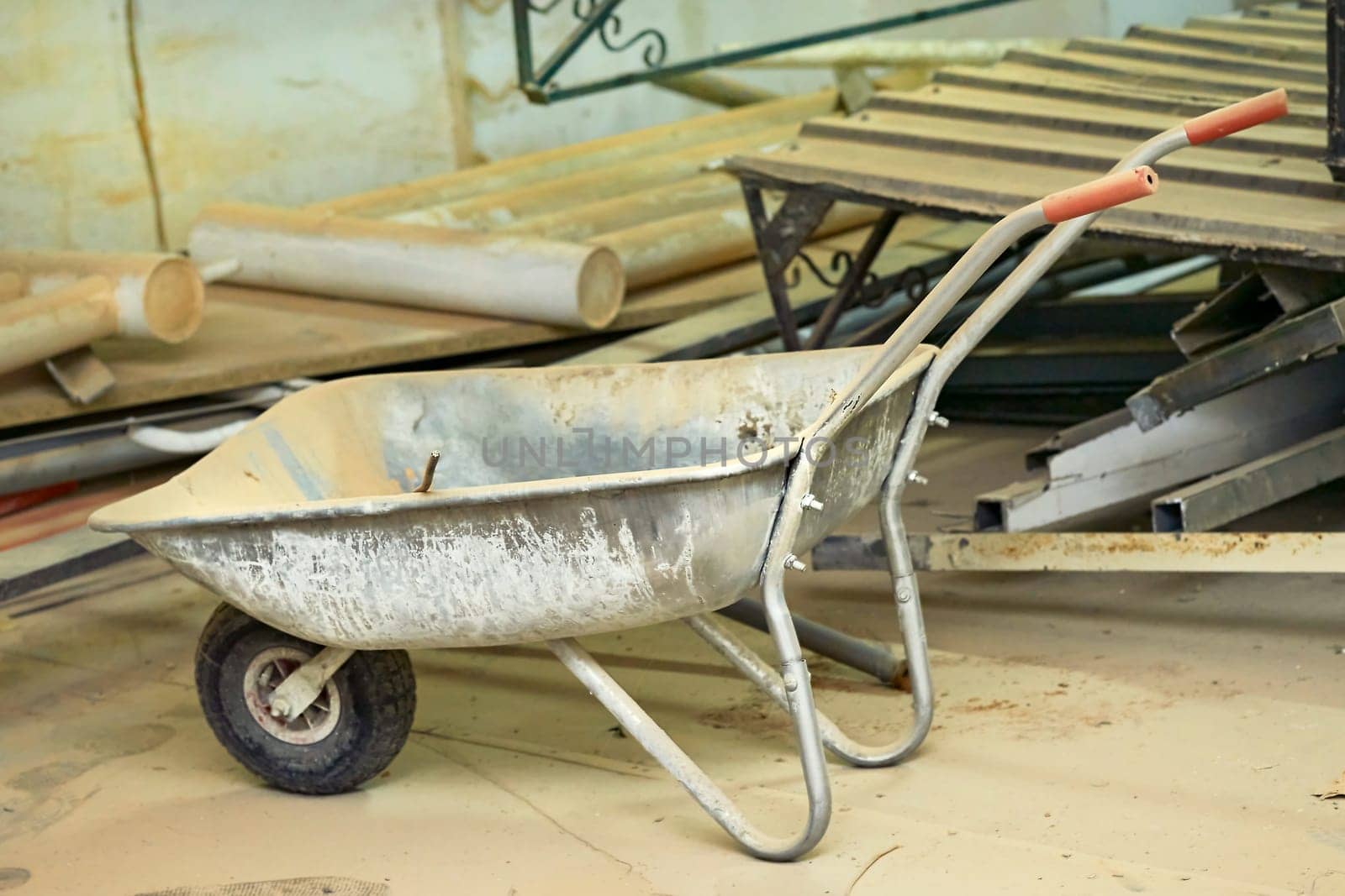 a small cart with a single wheel at the front and two supporting legs and two handles at the rear