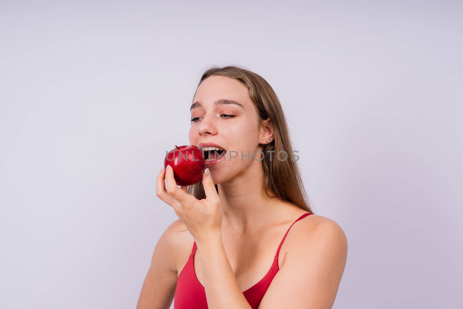 Cropped of sporty female with well fit body holding an apple, healthy food and fit body concept