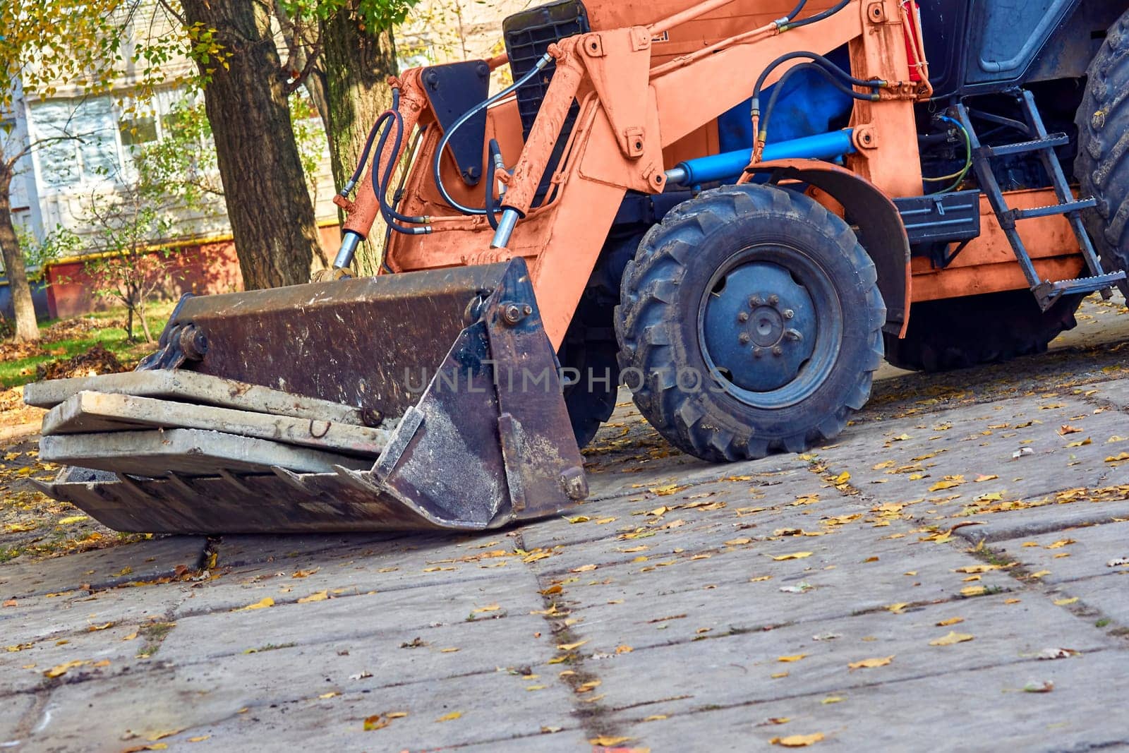 Excavator bulldozer loads old concrete slabs on road repair by jovani68