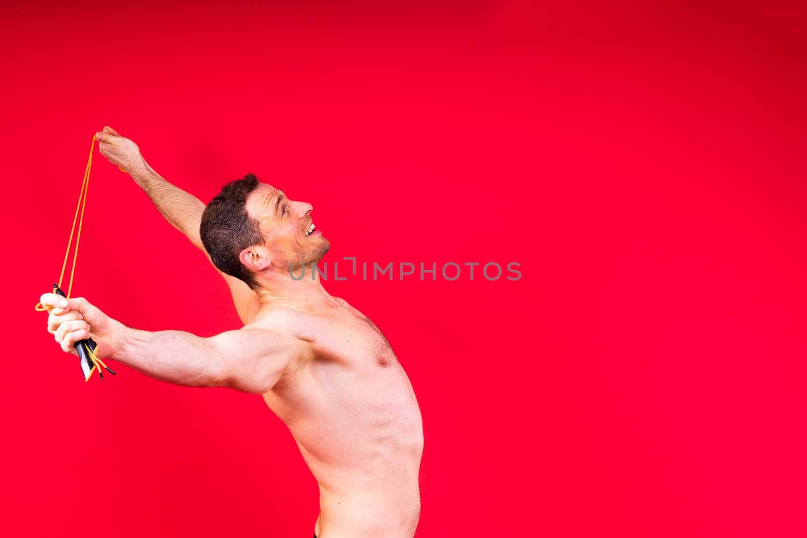 Full length portrait of a young man exercising with a skipping rope and looking at the camera by Zelenin