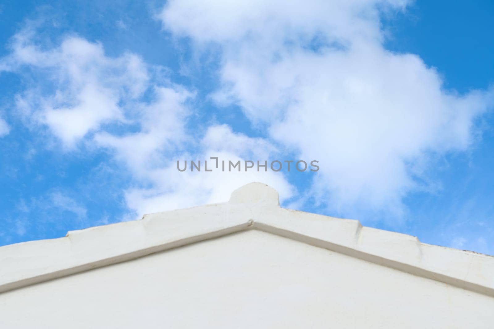 white building rooftop against vibrant blue sky with fluffy clouds by artgf