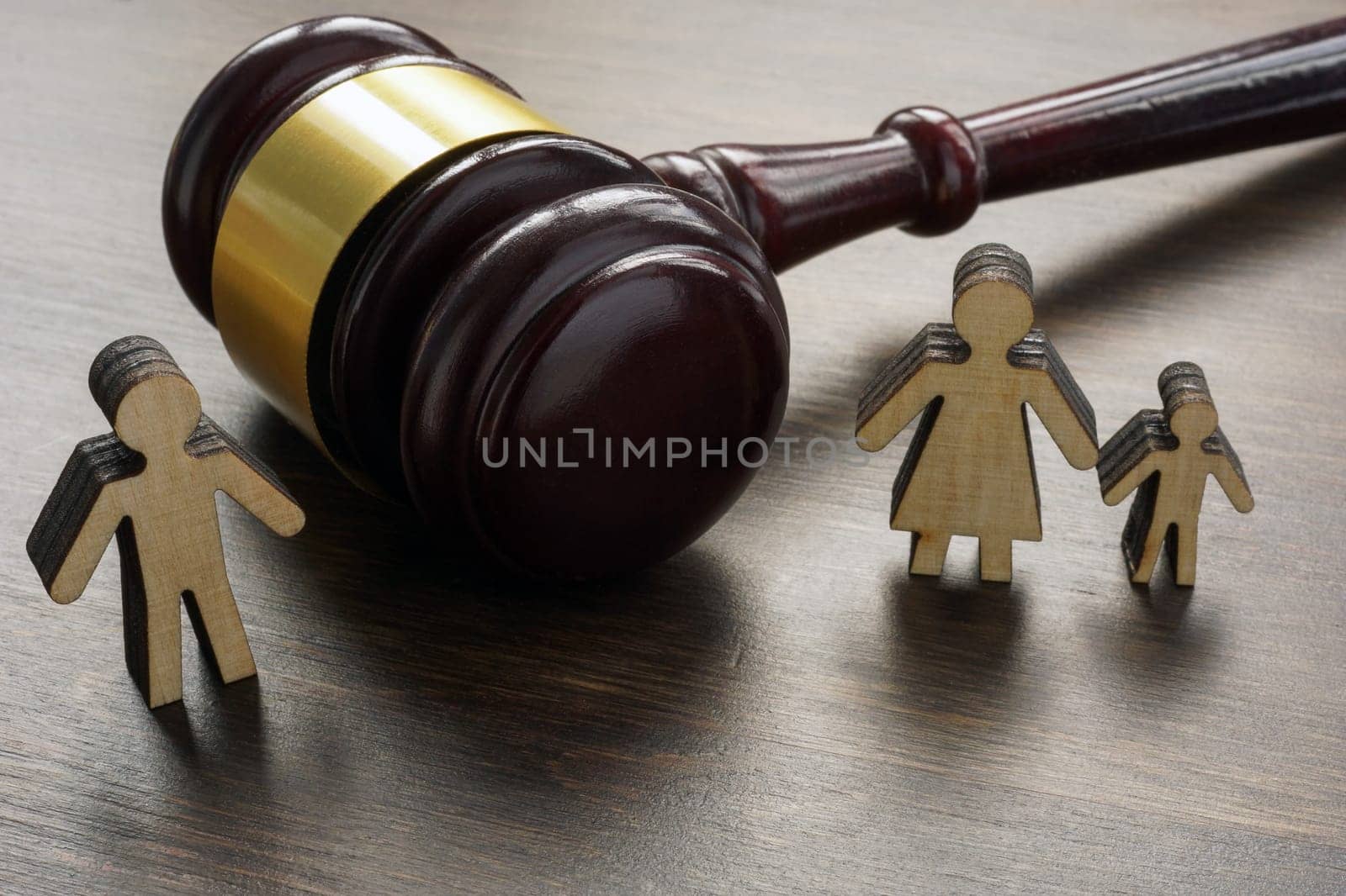 Divorce and alimony concept. Divided family figurines and gavel.