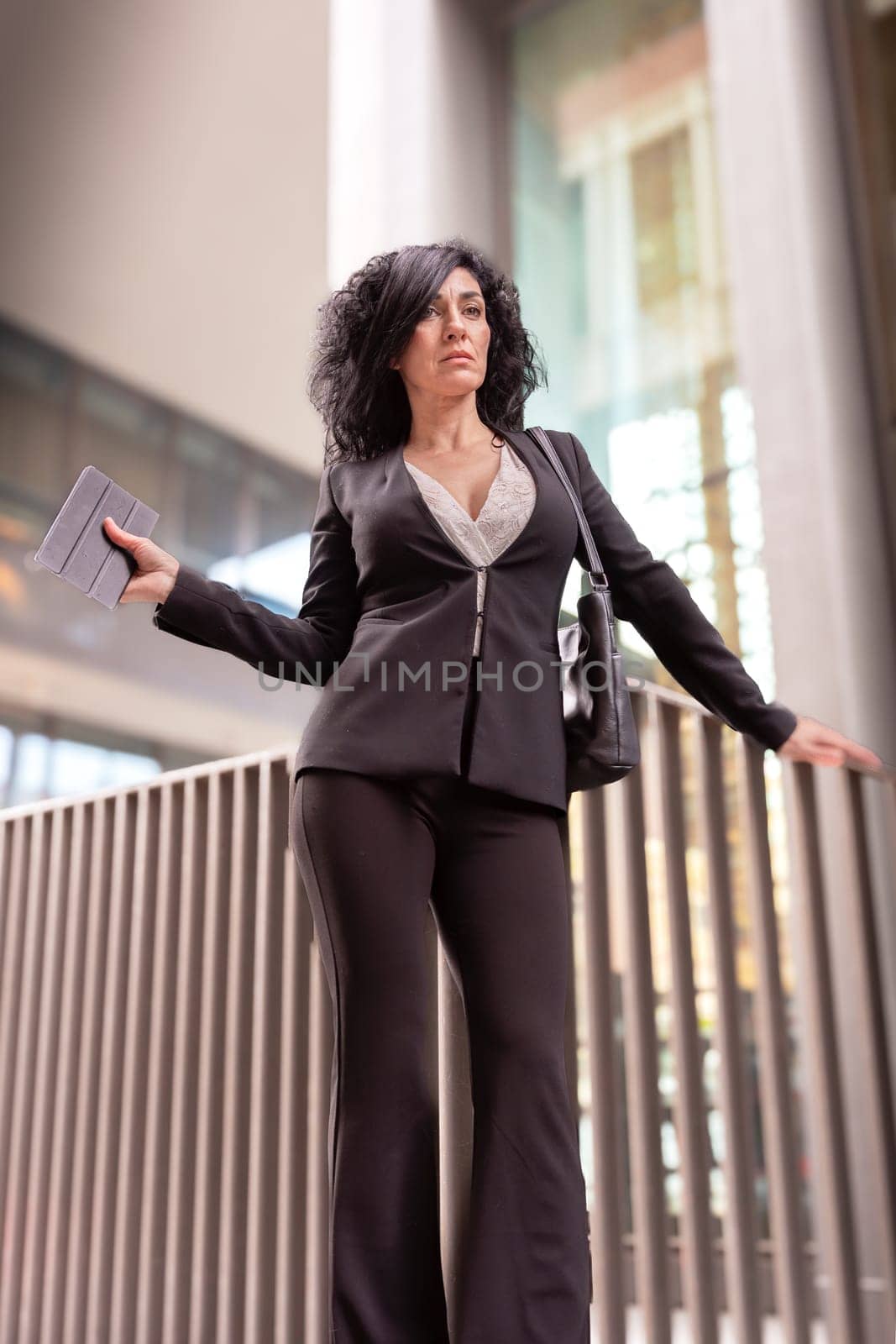 Middle Aged Caucasian Business Woman, Serious Standing With Digital Tablet In Hands.