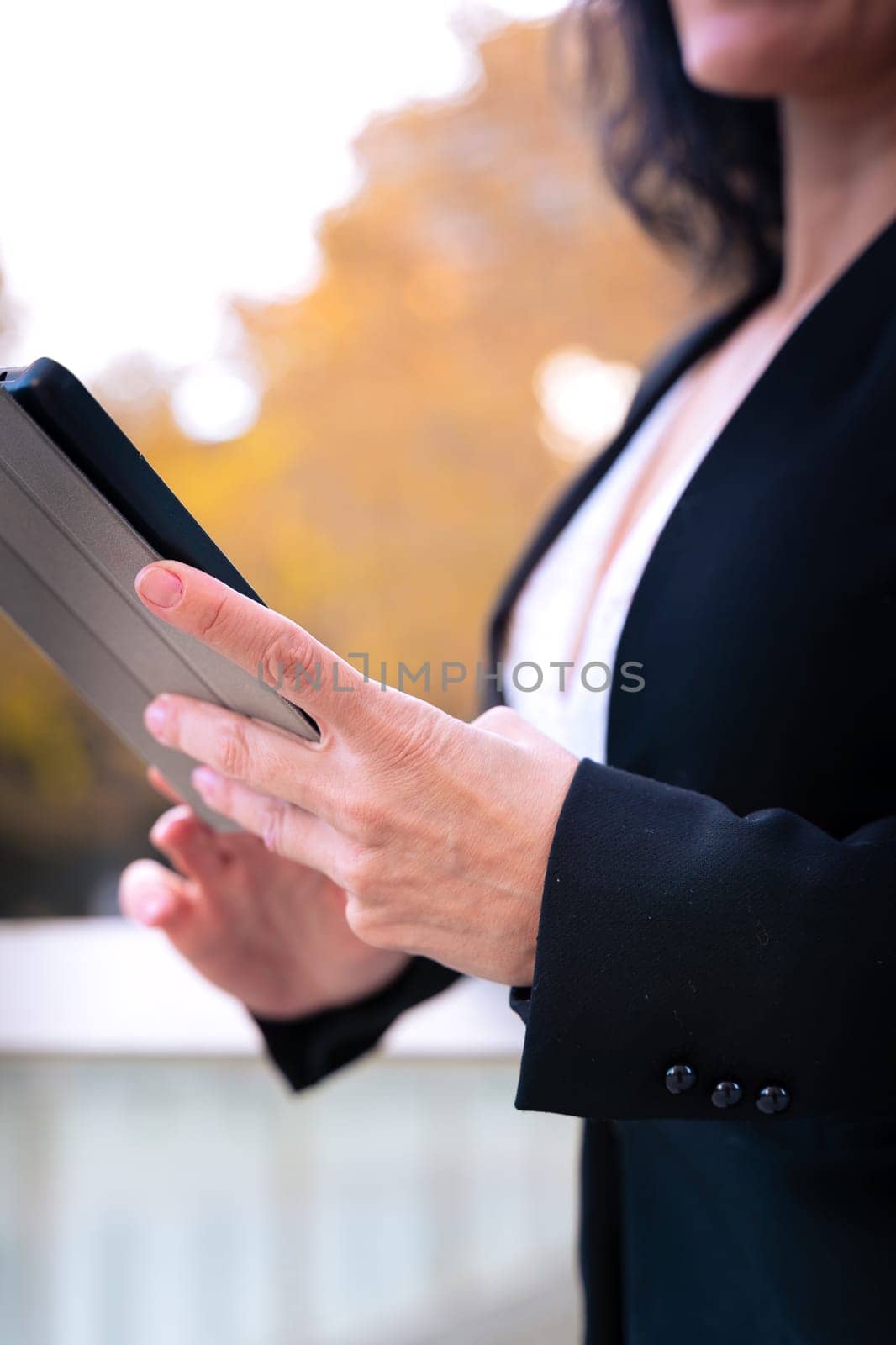 Portrait of a smiling middle-aged business woman with digital tablet in smiling hands looking at camera