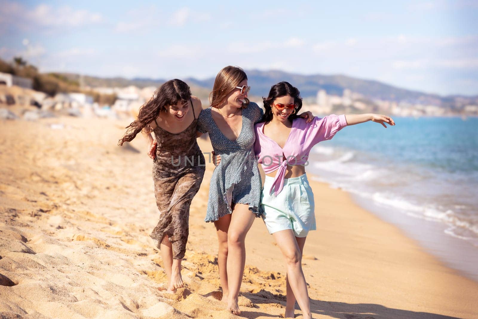 Portrait of three female friends walking on the beach having fun. by molesjuny