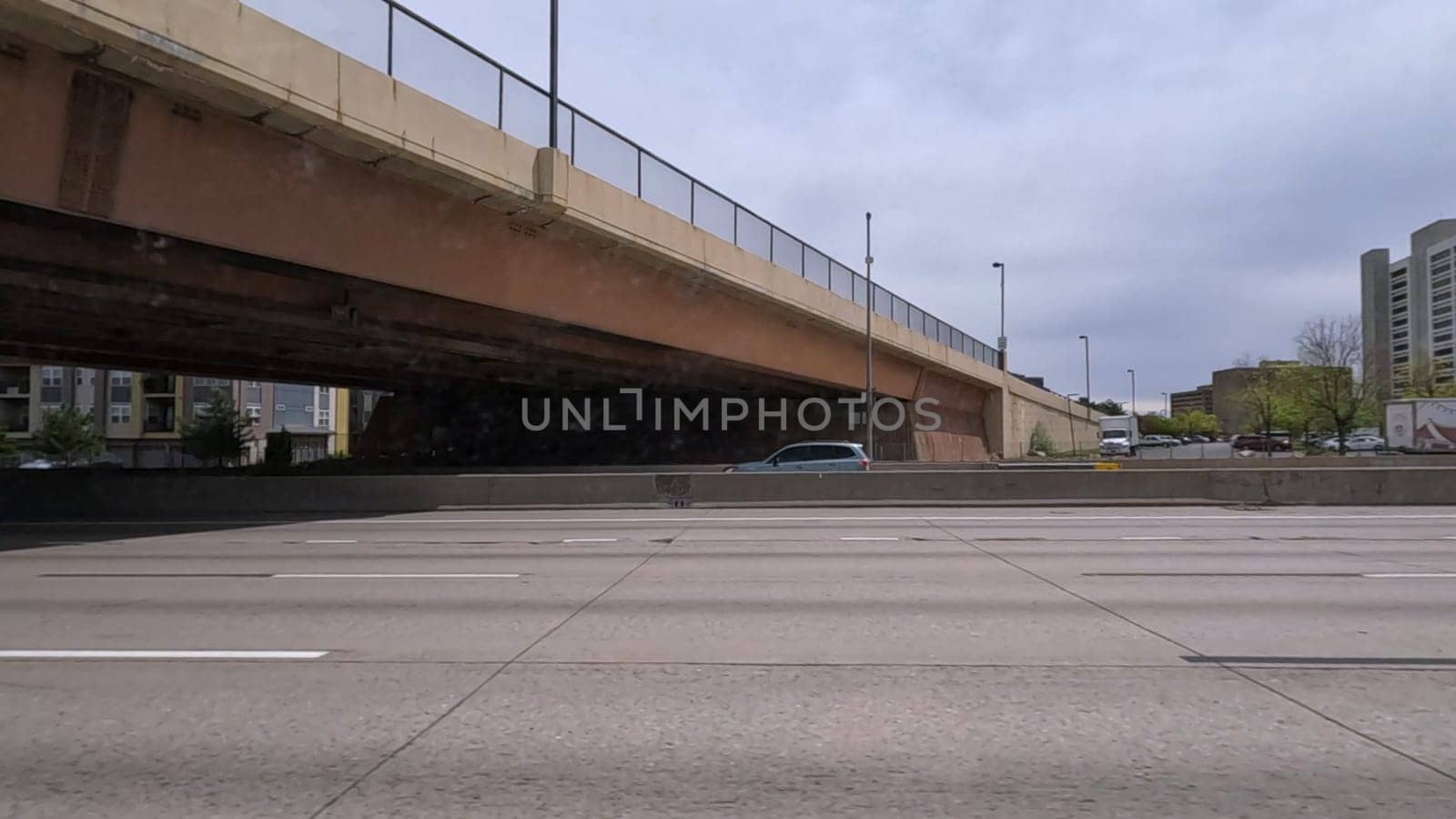 A dynamic view of the elevated highway overpass in South Denver, showcasing the intricate concrete structures and modern road design. The image captures the expansive lanes and surrounding landscape under a cloudy sky.