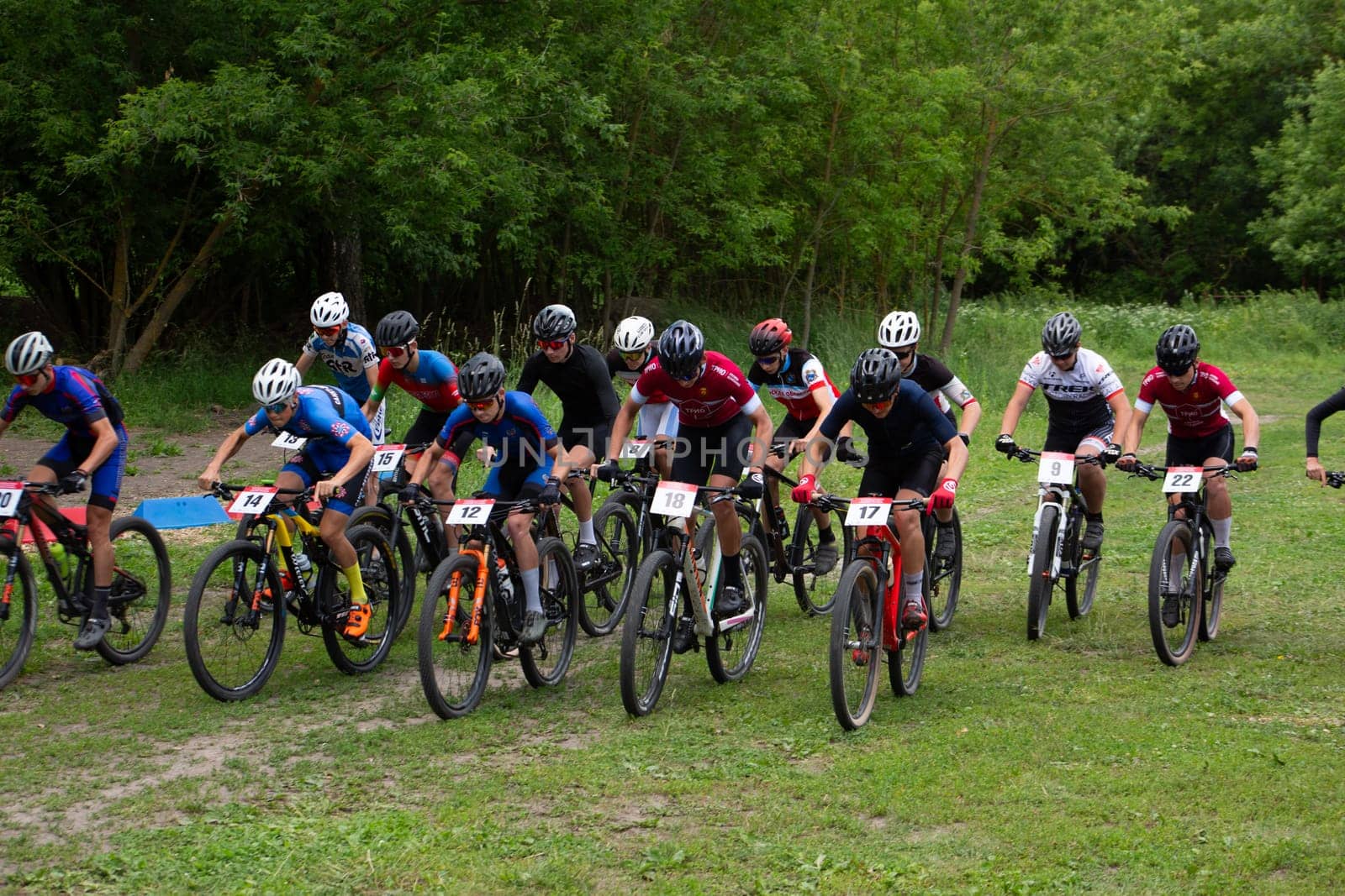 Kursk, Russia, June 15, 2024: Group of cyclists pick up speed after the start of the competition, starting acceleration of athletes on bicycles over rough terrain