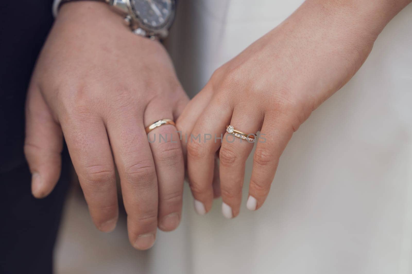 Married couple holding hands with rings wedding day