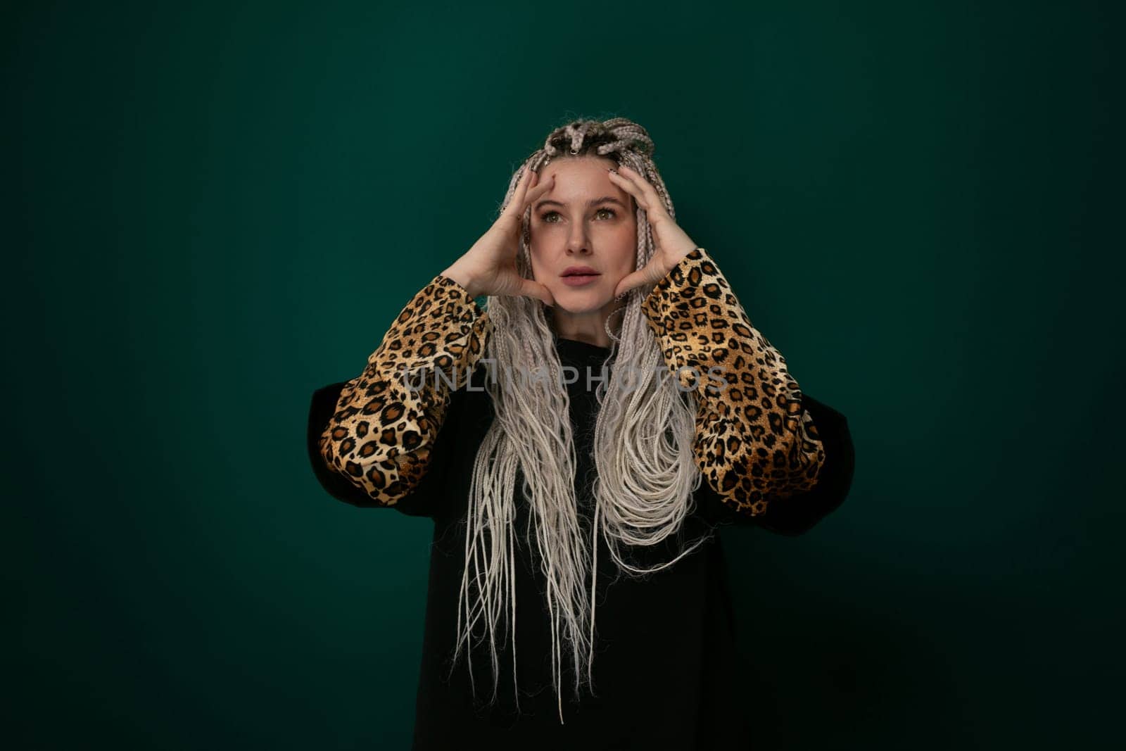 A woman with long white hair is wearing a stylish leopard print jacket. She exudes confidence and fashion-forward style as she walks down the street.