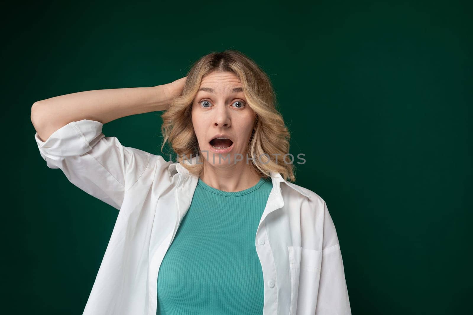 A woman is shown with a look of surprise on her face, eyes widened and mouth slightly open. Her facial expression conveys astonishment or shock about something unexpected.