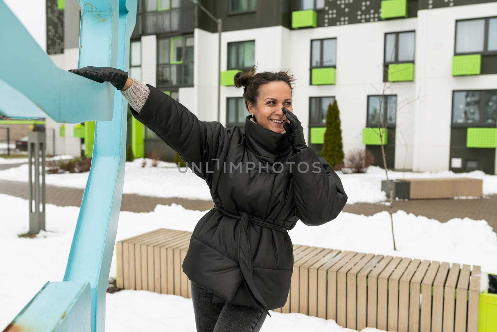 Lifestyle concept, a young woman dressed in a black jacket walks on a day off on the street in winter.