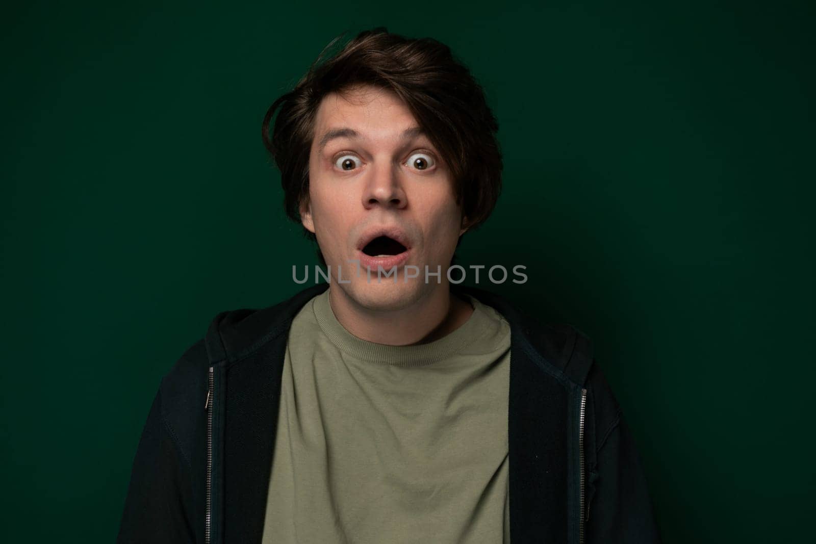 A man with a shocked expression on his face, eyes wide open and mouth slightly agape. His eyebrows raised, indicating surprise or astonishment. It is clear that something unexpected has caught his attention.