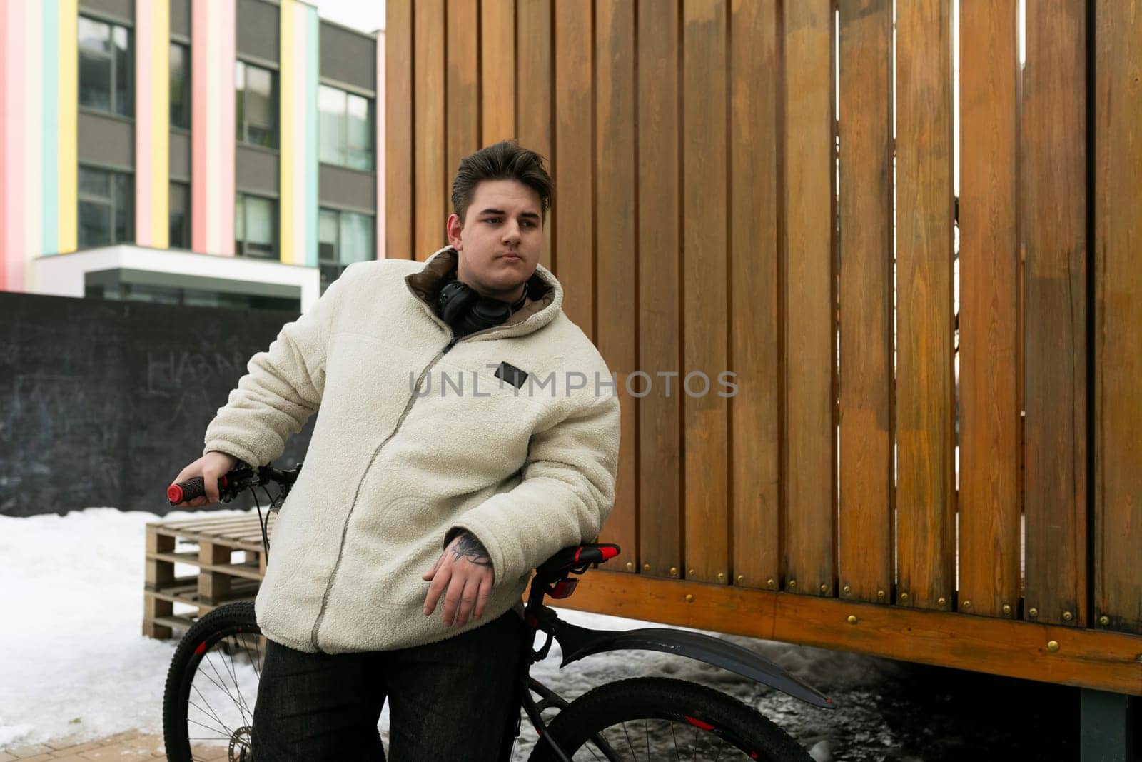 Young European man with a bicycle in an urban environment.