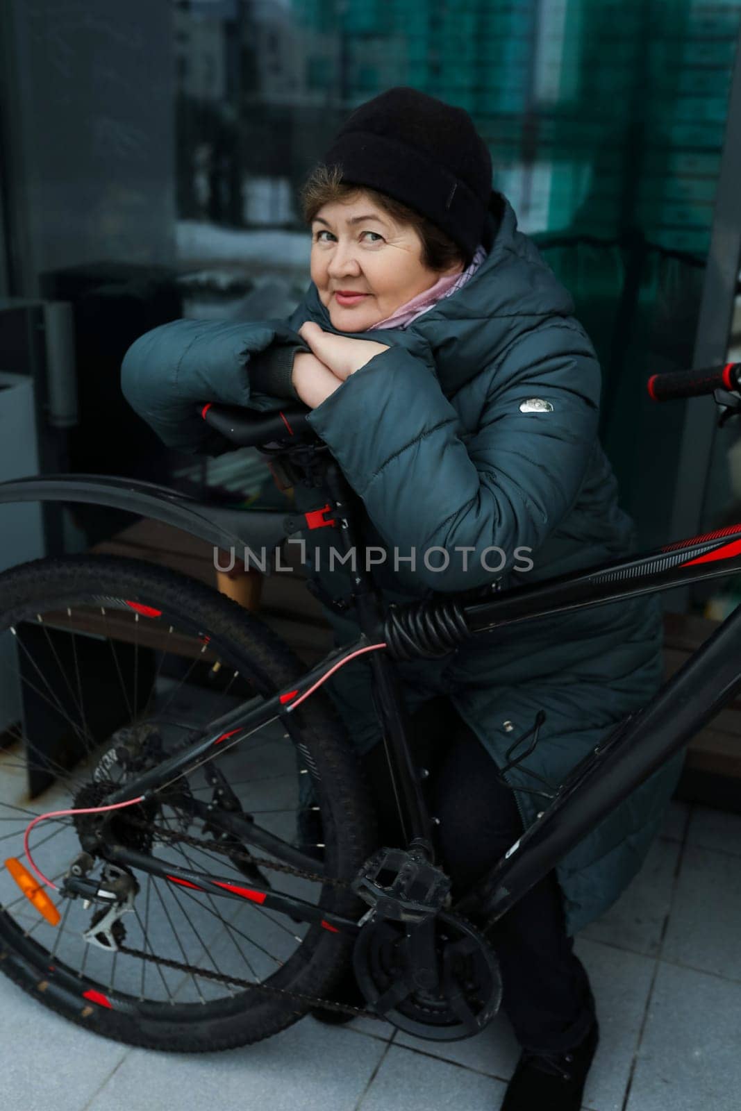 Mature European woman sat down to rest during a bike ride around the city.