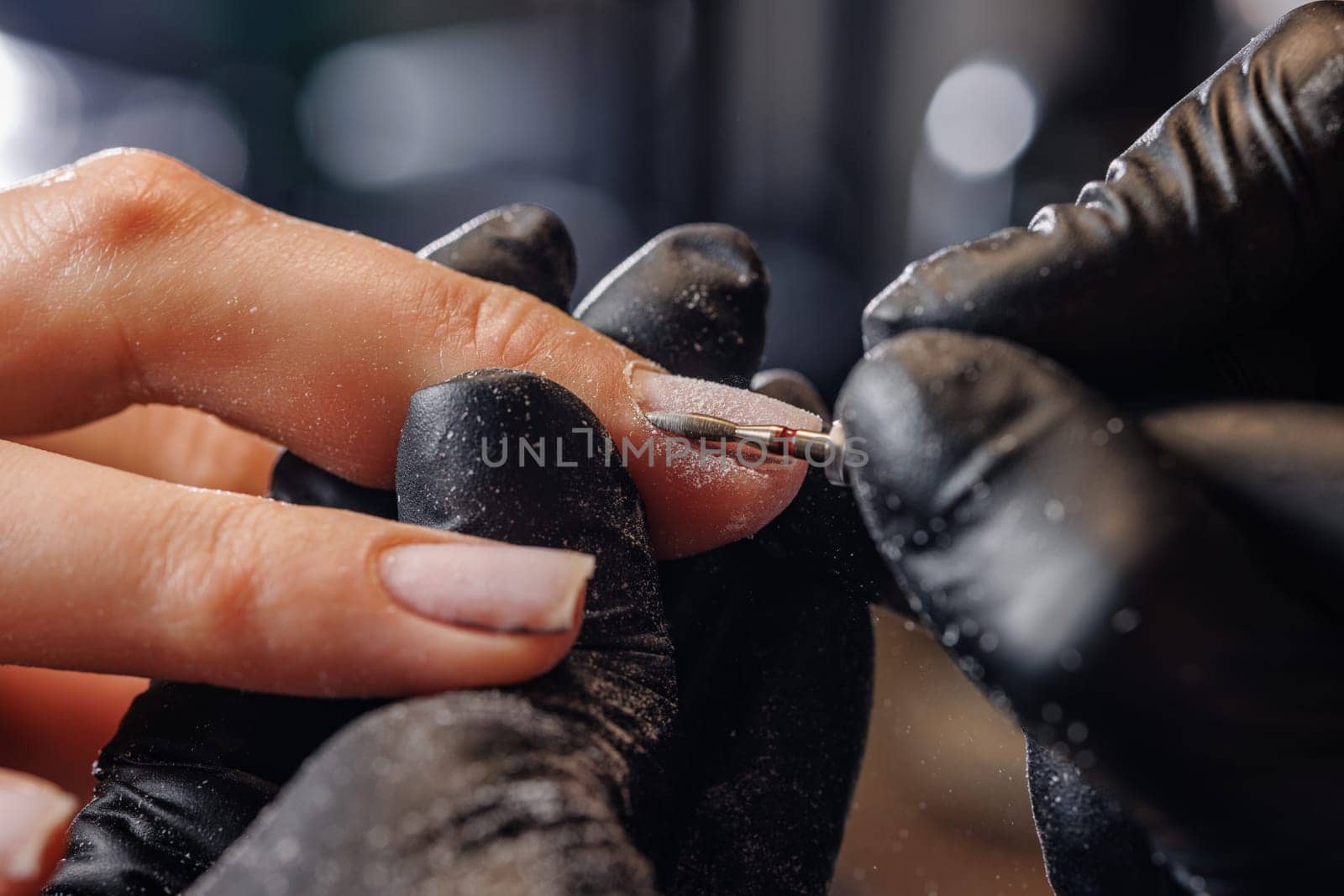 A manicurist gives a hardware manicure to a client using special tools. nail salon, self care concept