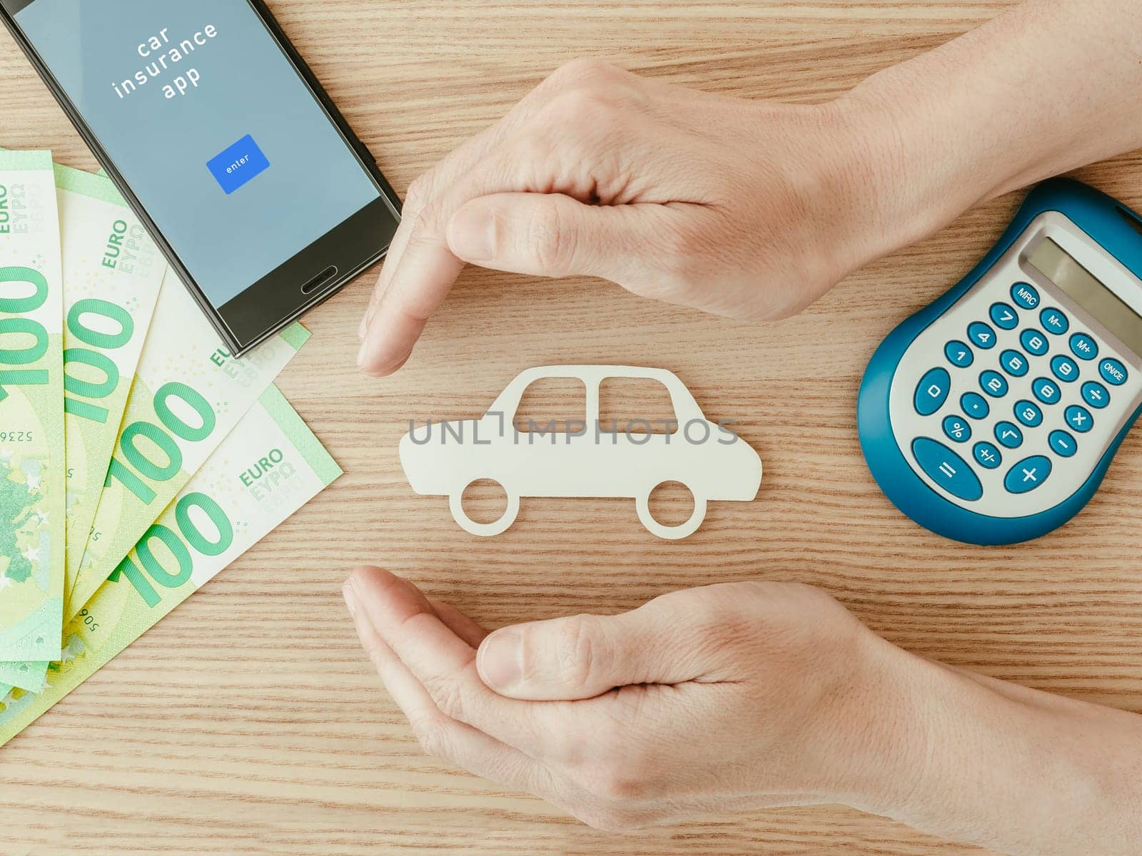 Car insurance concept with euros, smartphone and calculator. Close up