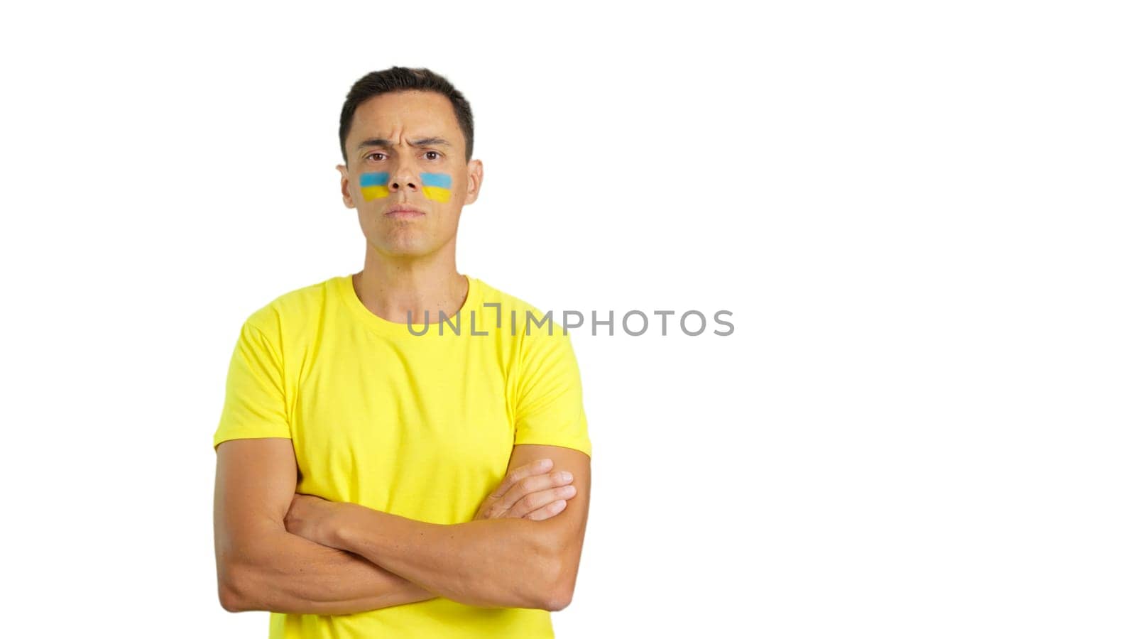 Dignified and serious man with ukrainian flag painted on face looking the camera with dignity