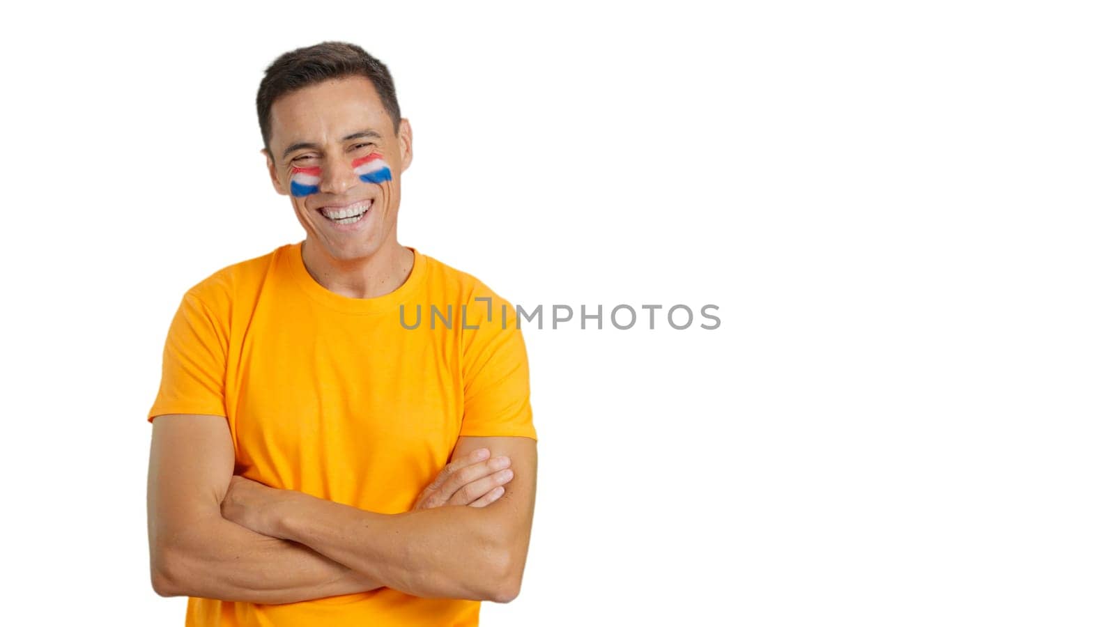 Man standing with dutch flag painted on face smiling with arms crossed