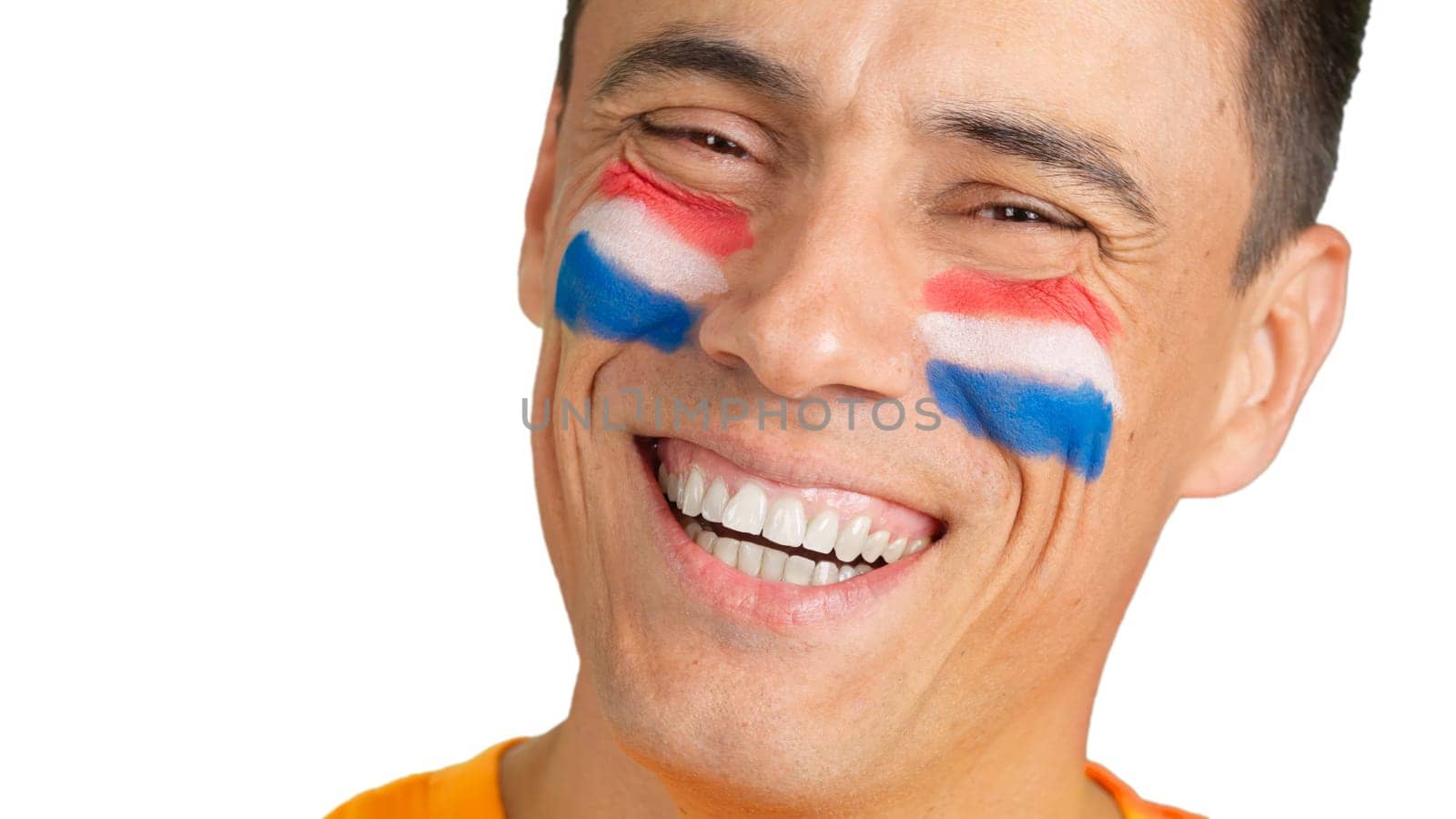 Close up of a man with a dutch flag painted on the face smiling at camera