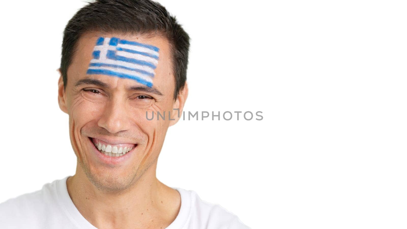 Close up of a man with a greek flag painted on the face smiling at camera