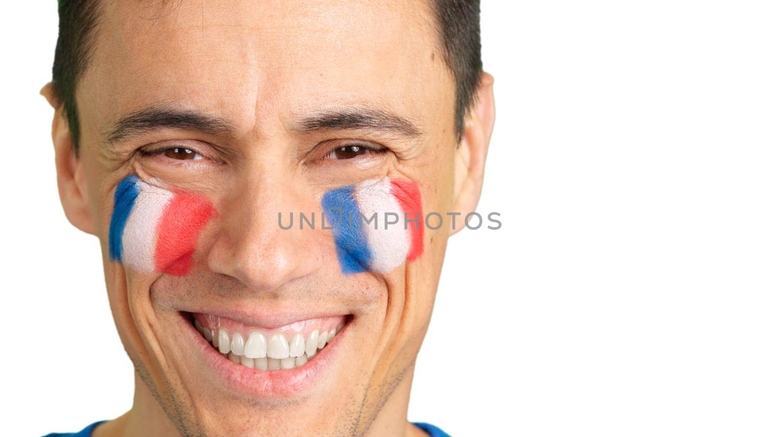 Close-up of a caucasian man with a french flag painted on the face smiling at camera