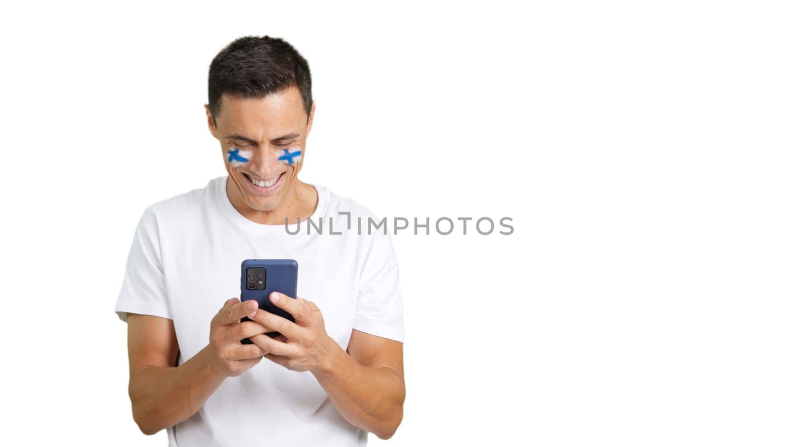 Finnish supporter with the flag of Finland painted on his face, looking at his mobile phone smiling