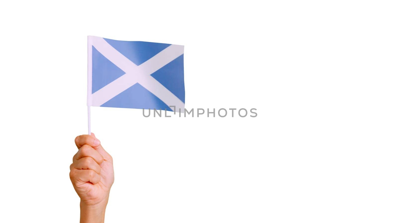 Photo of wind waving a scottish pennant holding by a hand.