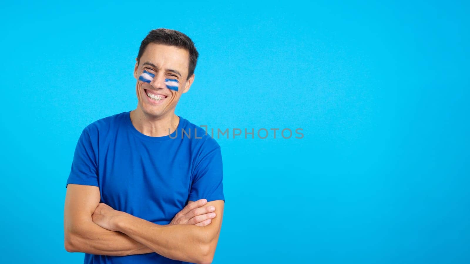 Man standing with salvadoran flag painted on face smiling by ivanmoreno