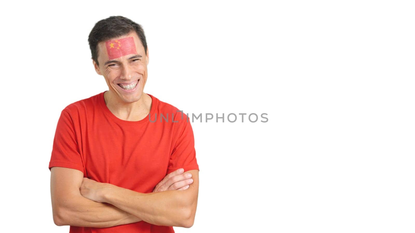 Man standing with chinese flag painted on face smiling with arms crossed