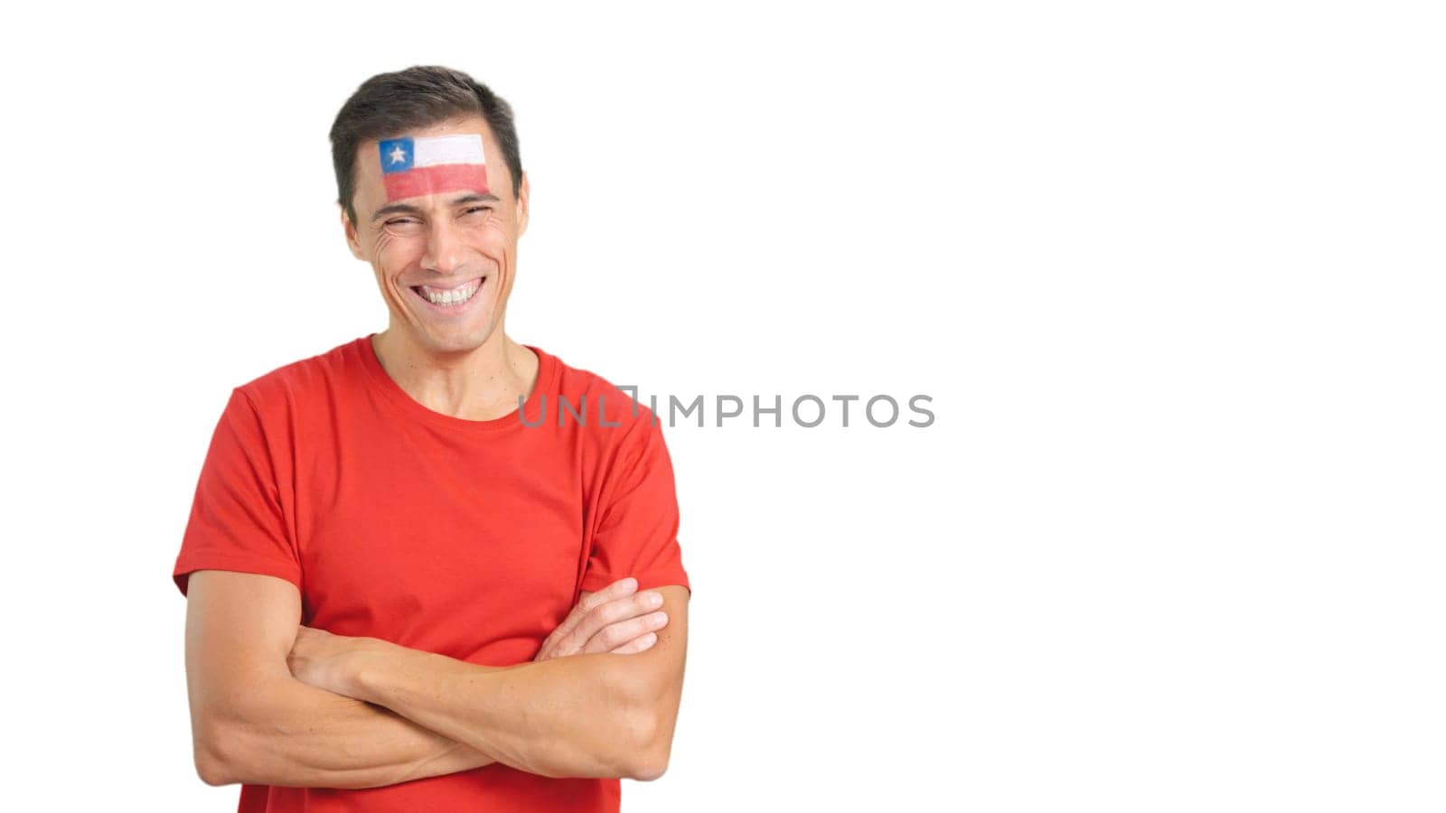 Man standing with chilean flag painted on face smiling with arms crossed