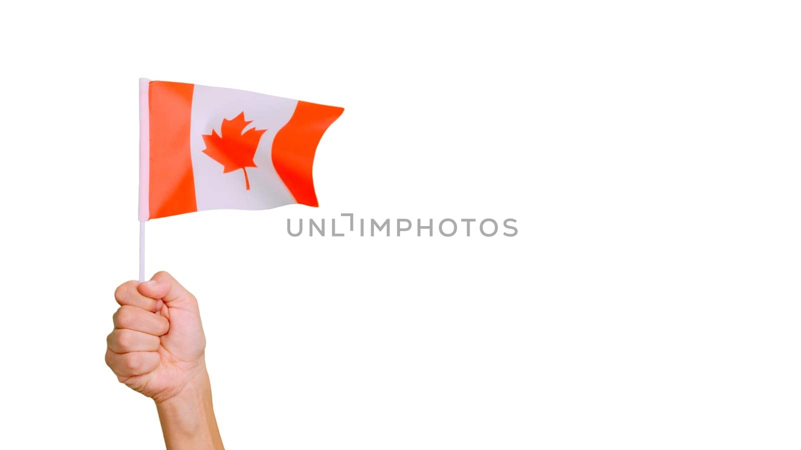 Photo of wind waving a canadian pennant holding by a hand.