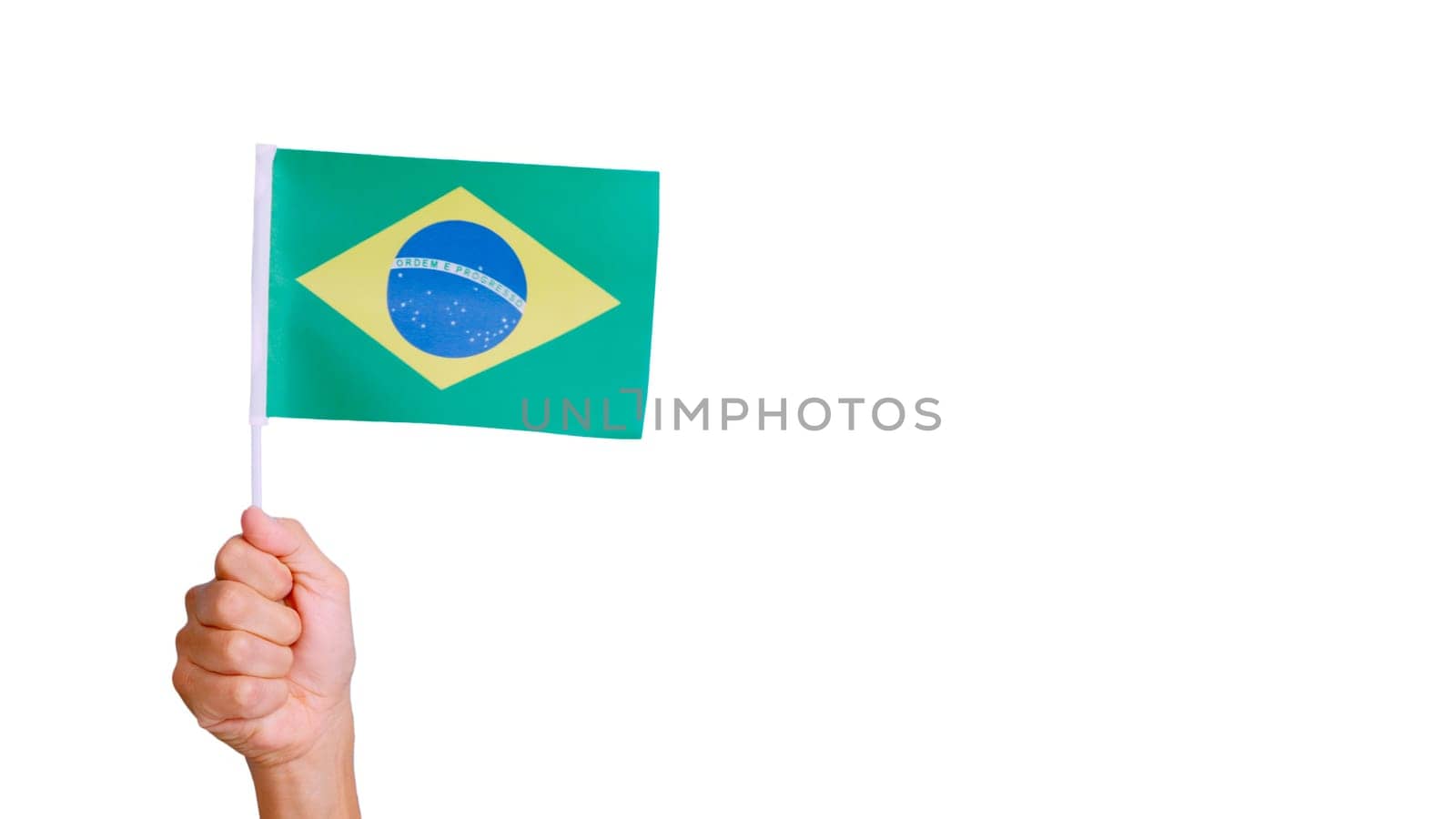 Photo of wind waving a brazilian pennant holding by a hand