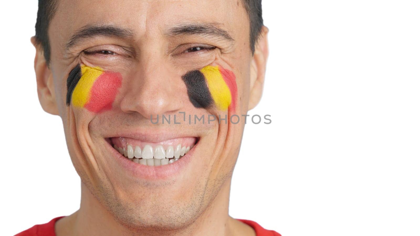 Close up of a man with a belgian flag painted on the face smiling at camera