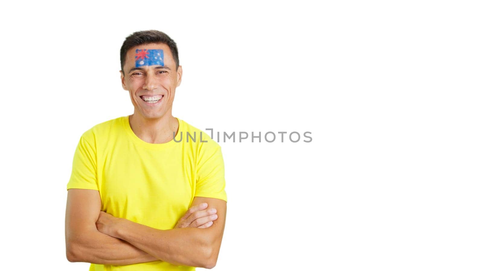 Man standing with australian flag painted on face smiling with arms crossed