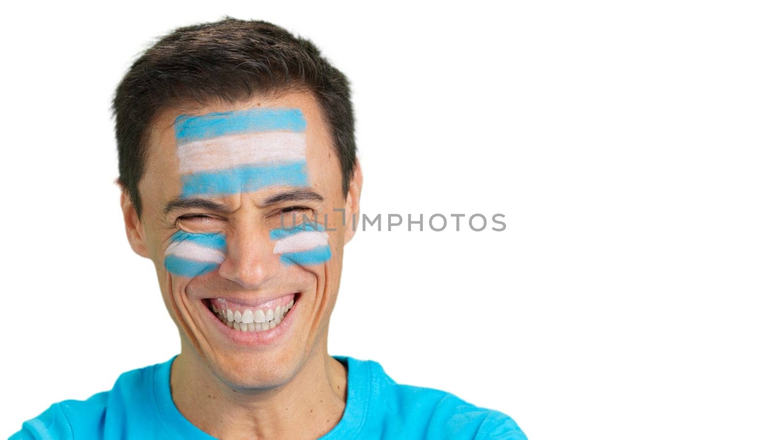 Close up of a man with a argentine flag painted on the face smiling at camera