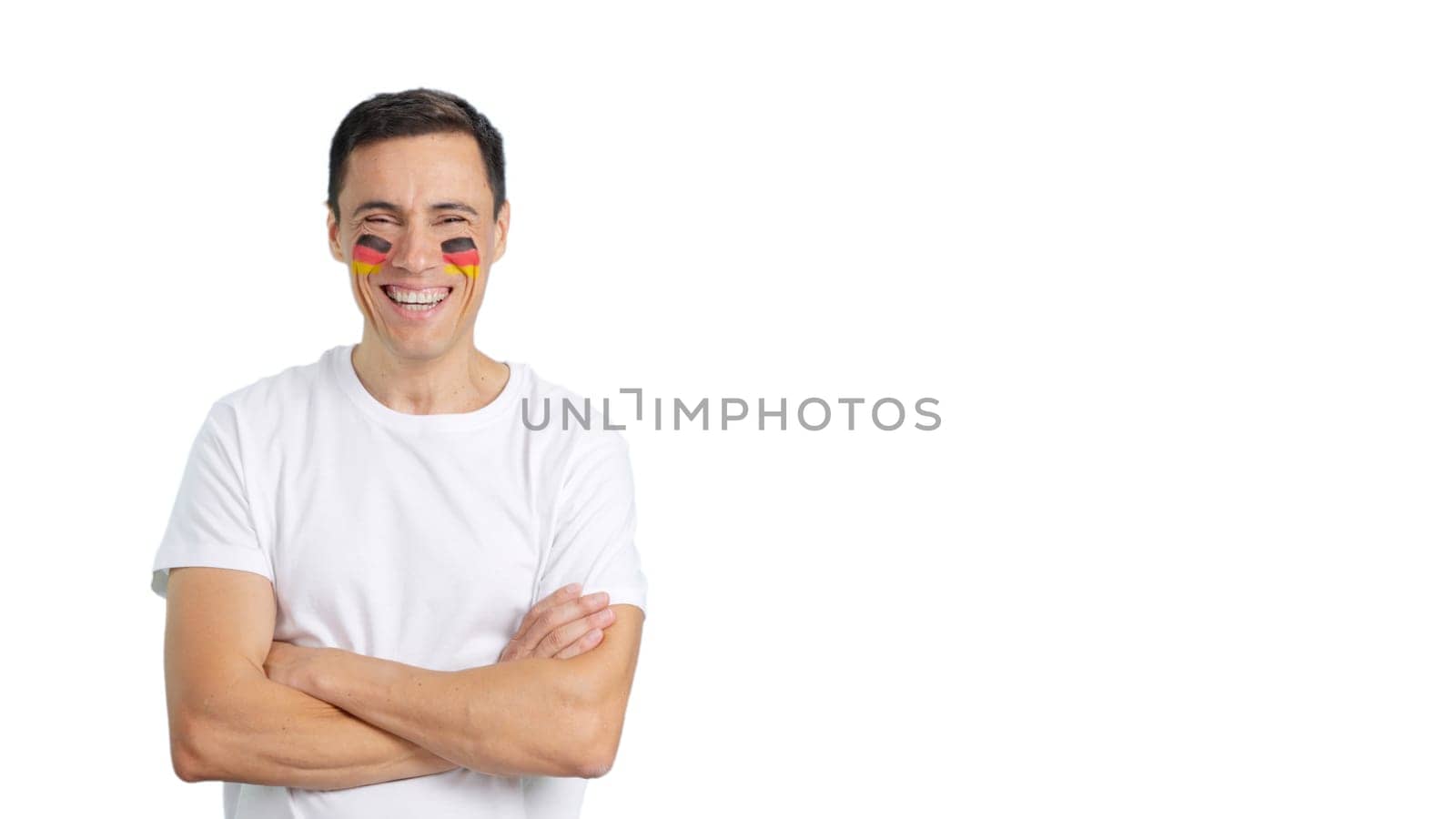 Man standing with german flag painted on face smiling with arms crossed