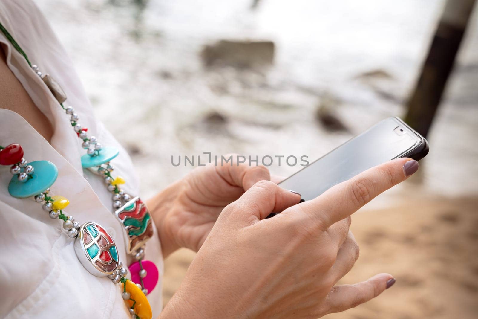 Portrait close up of young woman using smartphone app outdoors. by mariaphoto3