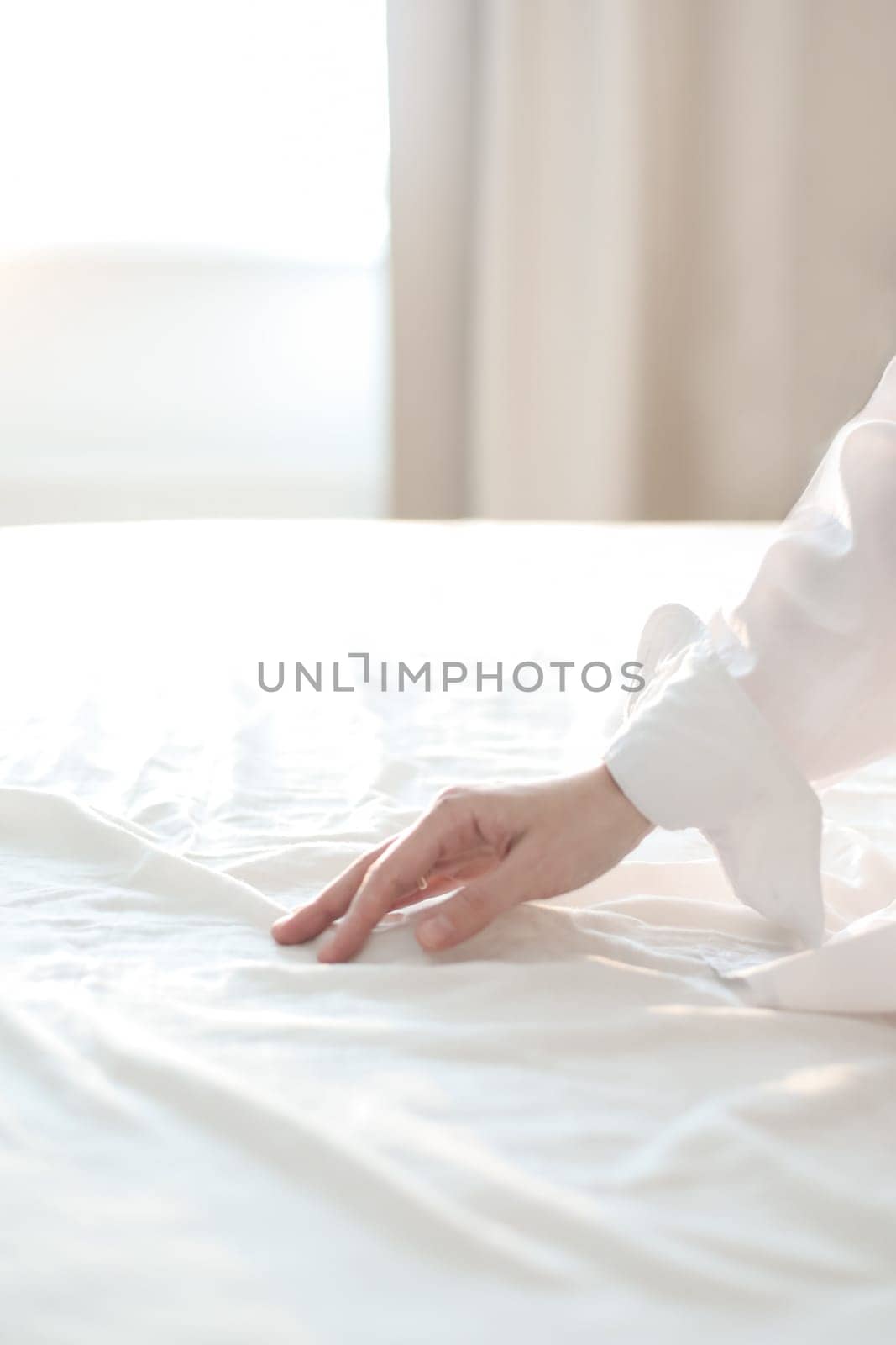 Woman Hand touching bed sheets, closeup. Young woman intimacy on bed. Soft, gentle, tender cozy morning concept