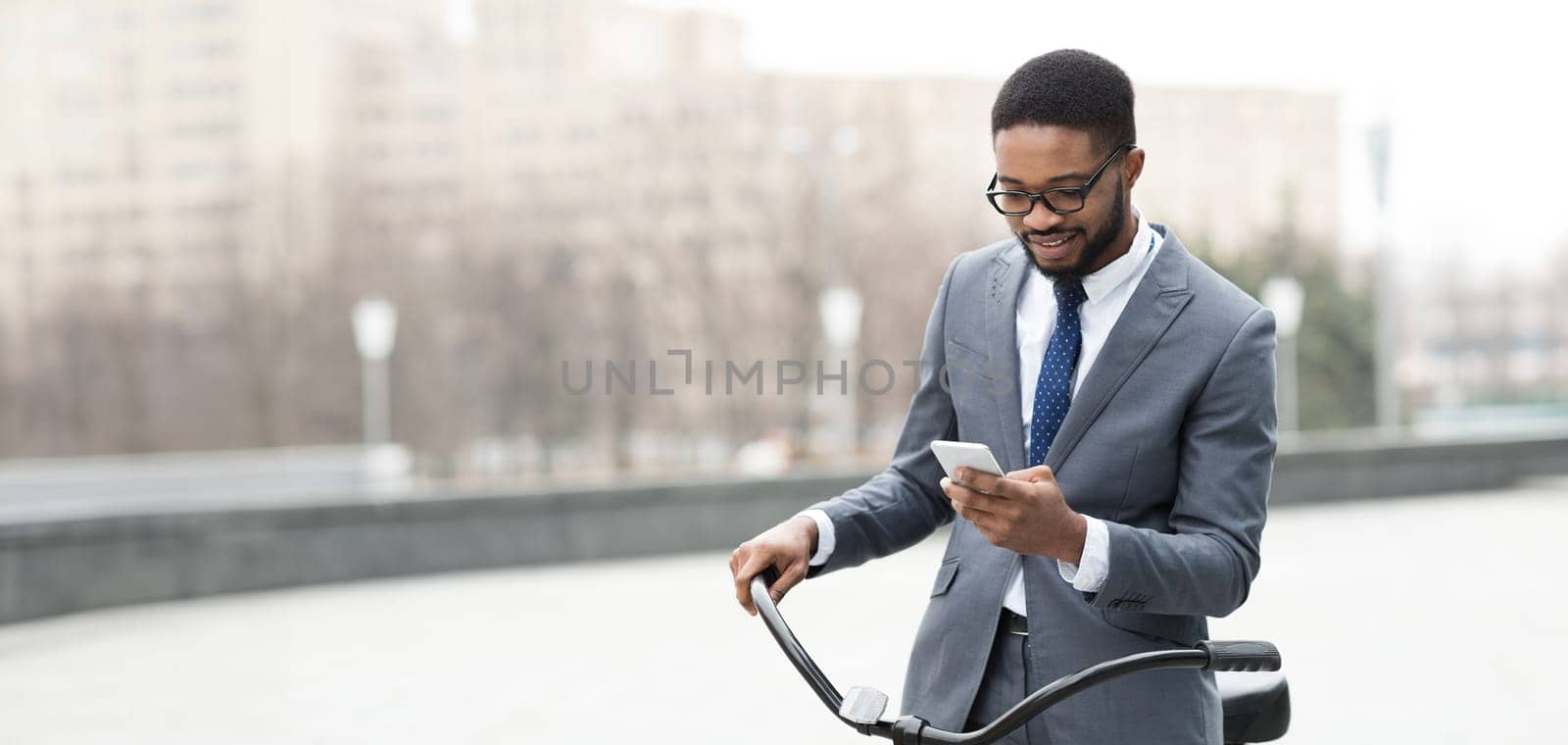 Black man is on his bike in the city, focused on his phone. The mood is dynamic and professional, reflecting the multitasking lifestyle of a modern urban professional.